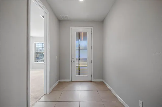 a view of an empty room with closet and a window