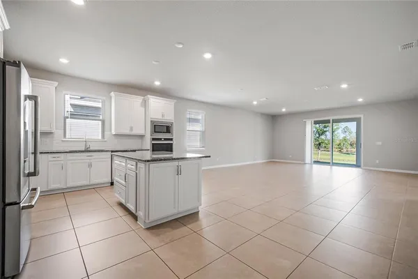 a kitchen with white cabinets appliances and a sink