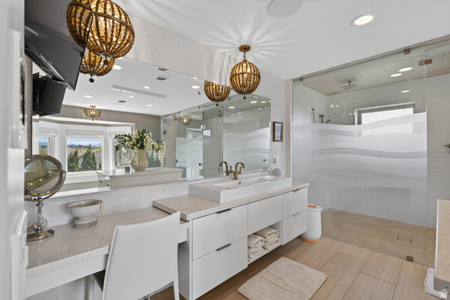 12308 Mariah Circle Draper, UT 84020 - Photo 69 of 293 Spacious bathroom featuring a double vanity with integrated sink, glass-enclosed shower with frosted wave design, recessed lighting, and ornate pendant light fixtures