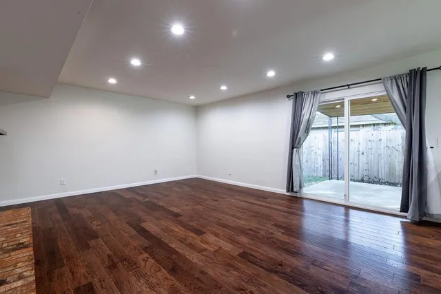 an empty room with wooden floor and door
