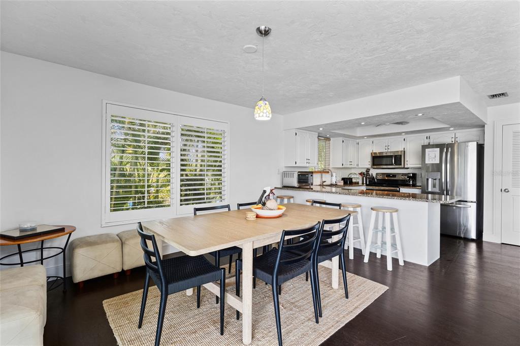 315 Spring Avenue Anna Maria, FL 34216 - Photo 16 of 63 a view of a dining room with furniture and wooden floor