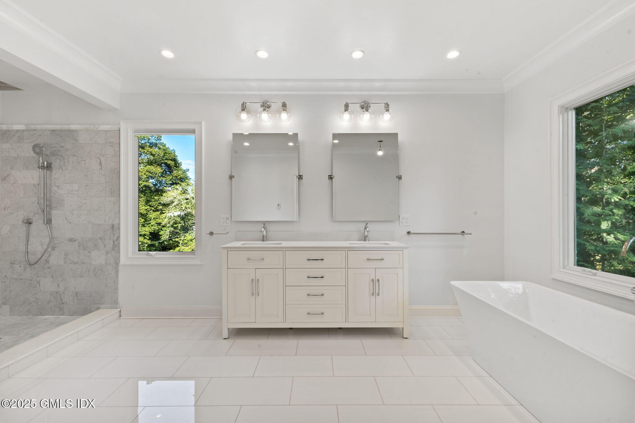 22 Carleton Street Greenwich, CT 06830 - Photo 11 of 26 a spacious bathroom with a double vanity sink a large mirror and a bathtub