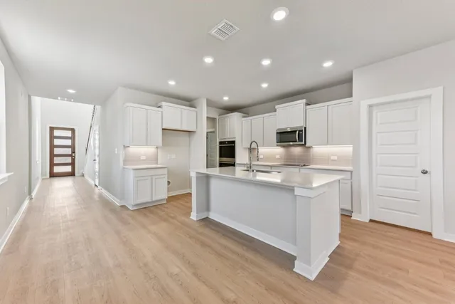 a kitchen with white cabinets and stainless steel appliances