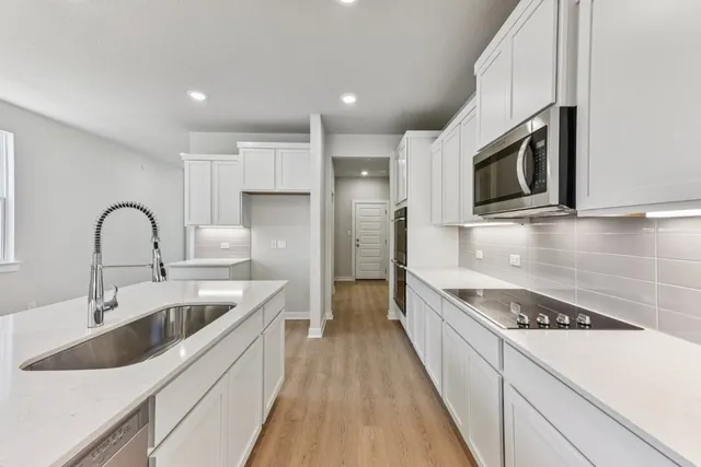 a kitchen with stainless steel appliances kitchen island a stove a sink and a microwave