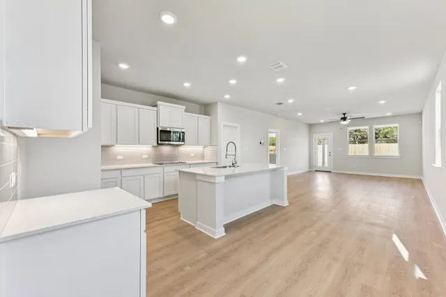 a large white kitchen with lots of counter top space and cabinets