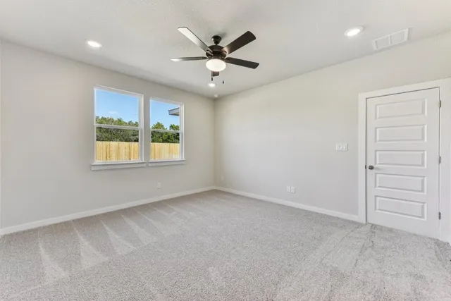 an empty room with closet and ceiling fan
