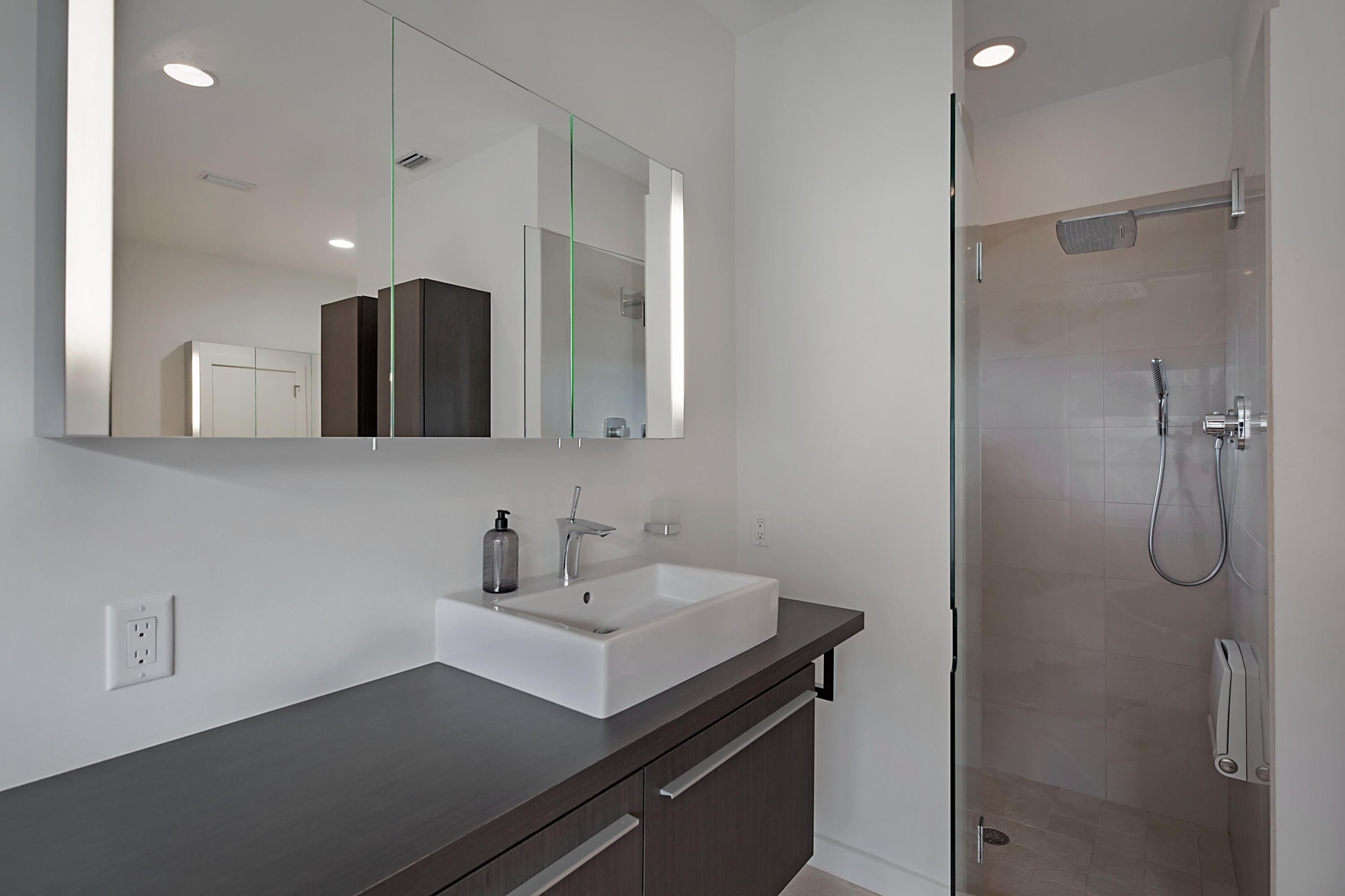 7316 Mandarin Drive Boca Raton, FL 33433 - Photo 23 of 45 a bathroom with a sink a light fixture and a glass door