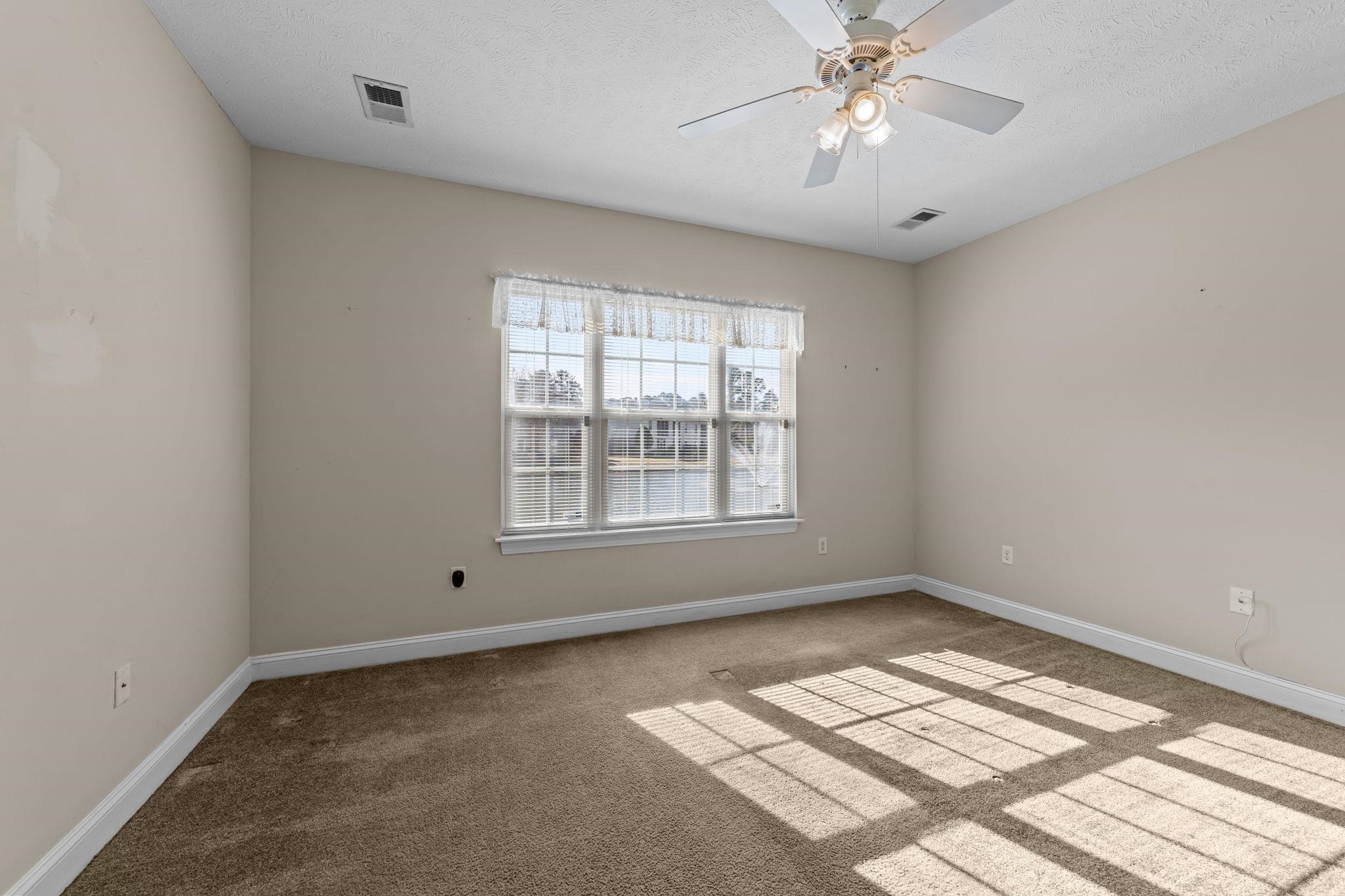 120 Fountain Pointe Lane, Unit 103 Myrtle Beach, SC 29579 - Photo 13 of 26 Carpeted spare room with ceiling fan and a textured ceiling