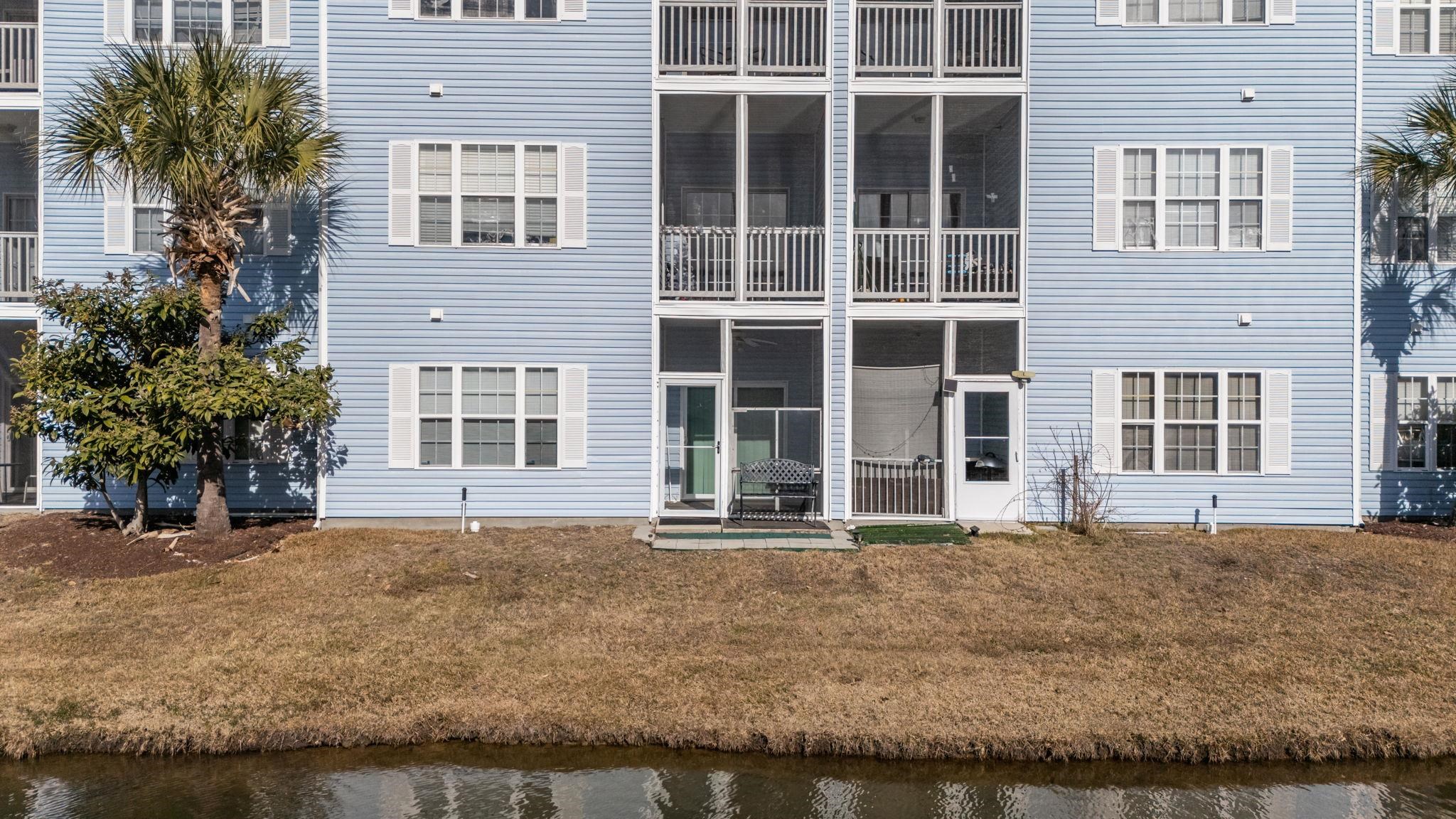 120 Fountain Pointe Lane, Unit 103 Myrtle Beach, SC 29579 - Photo 25 of 26 Back of house featuring a sunroom, a yard, and a balcony