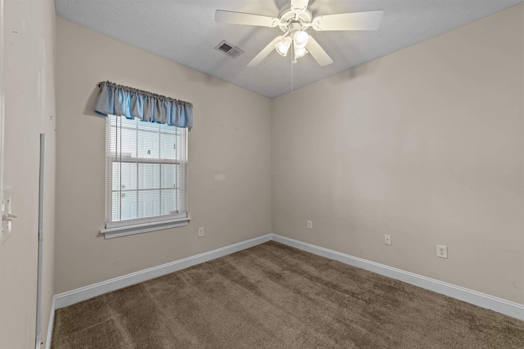 120 Fountain Pointe Lane, Unit 103 Myrtle Beach, SC 29579 - Photo 4 of 26 Carpeted spare room featuring a ceiling fan and a textured ceiling