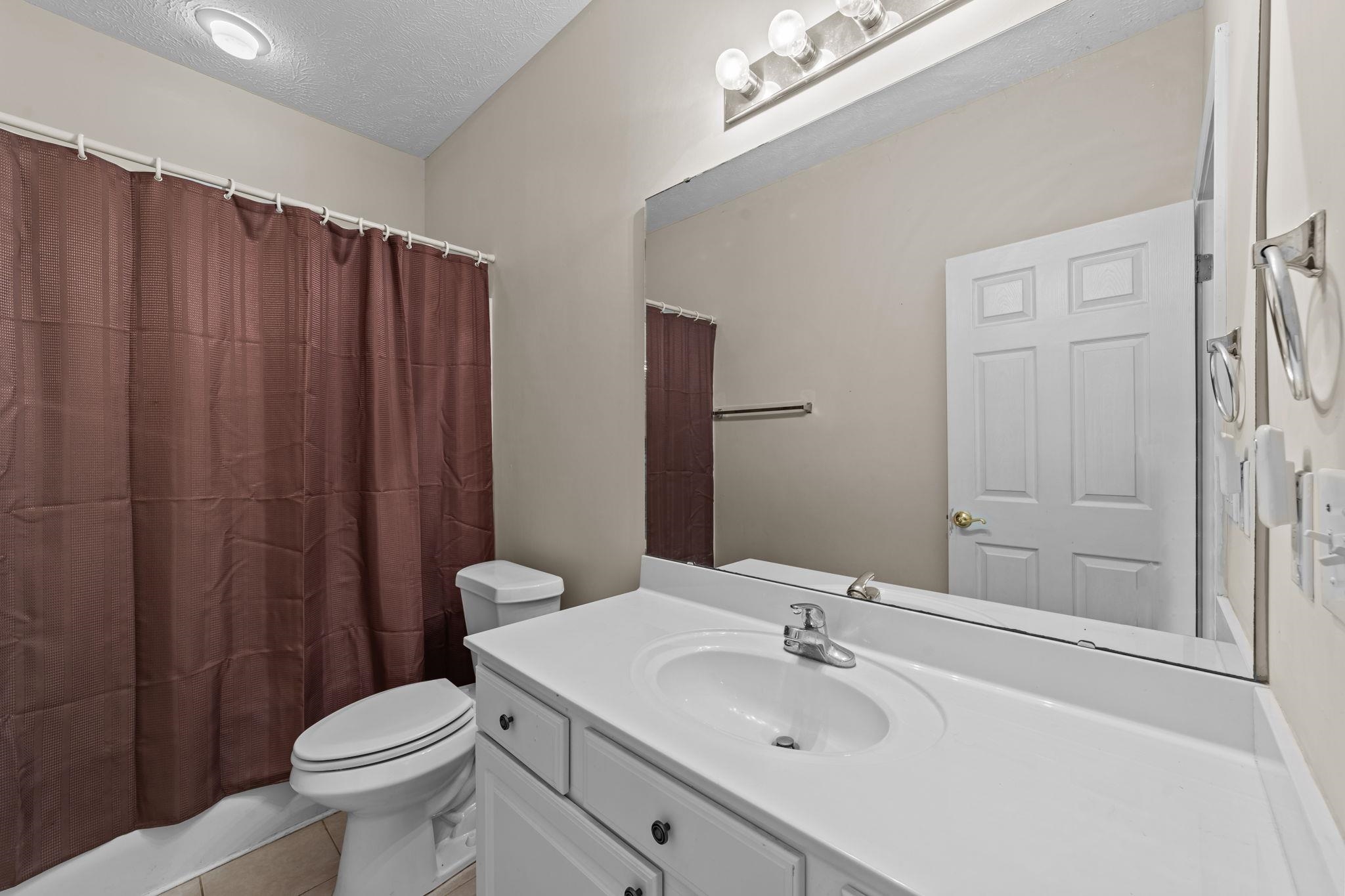 120 Fountain Pointe Lane, Unit 103 Myrtle Beach, SC 29579 - Photo 8 of 26 Full bath featuring vanity, a textured ceiling, shower / tub combo with curtain, and light tile patterned floors
