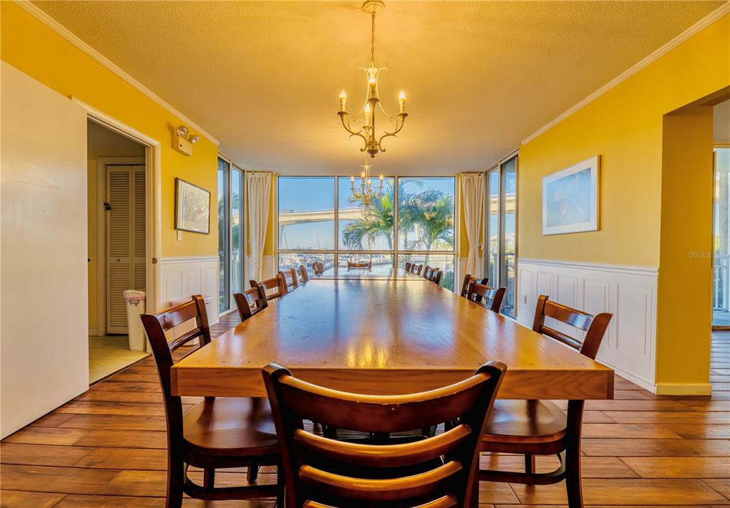 100 Pierce Street, Unit 1102 Clearwater, FL 33756 - Photo 34 of 45 a dining room with furniture a chandelier and wooden floor