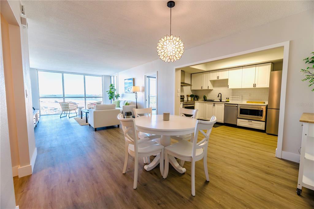 100 Pierce Street, Unit 1102 Clearwater, FL 33756 - Photo 7 of 45 a view of a dining room and livingroom with furniture wooden floor a chandelier