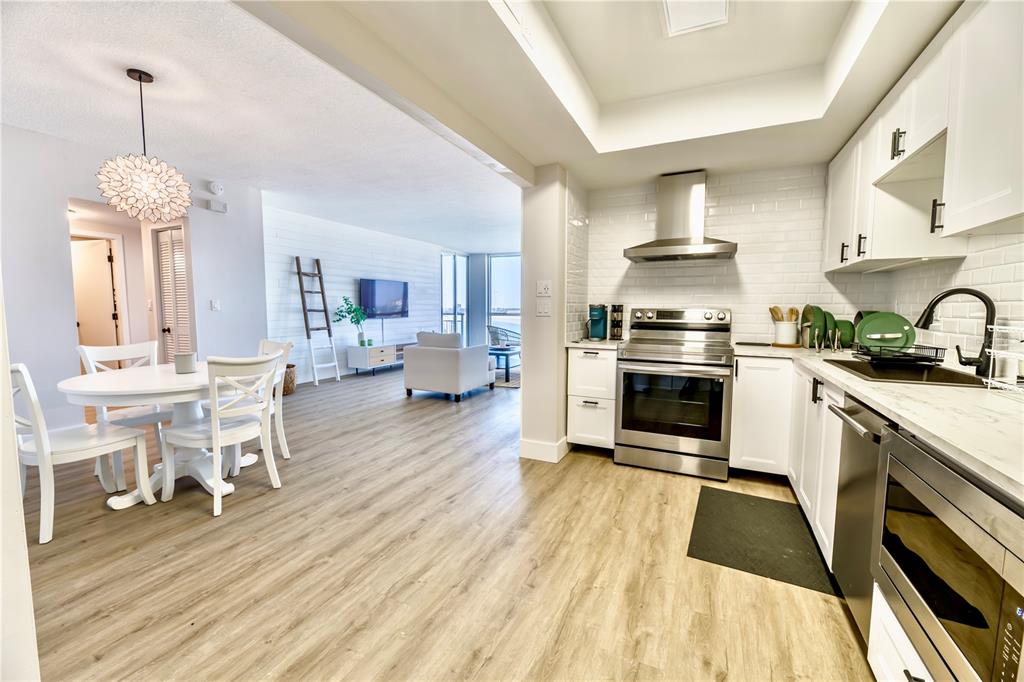100 Pierce Street, Unit 1102 Clearwater, FL 33756 - Photo 8 of 45 a kitchen with stainless steel appliances a dining table chairs stove and cabinets