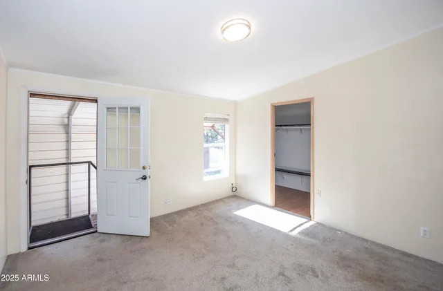 an empty room with windows and closet