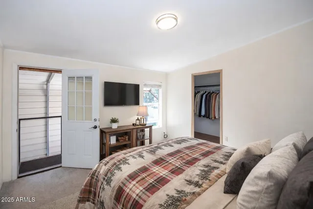 a bedroom with a bed and a flat tv screen on wall