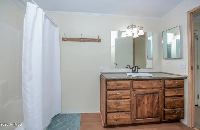 a bathroom with a granite countertop sink two mirror and a vanity
