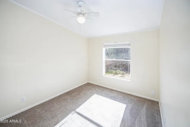 an empty room with a window and a fan