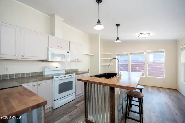 a kitchen with stainless steel appliances granite countertop a stove a sink dishwasher and a refrigerator with wooden floor