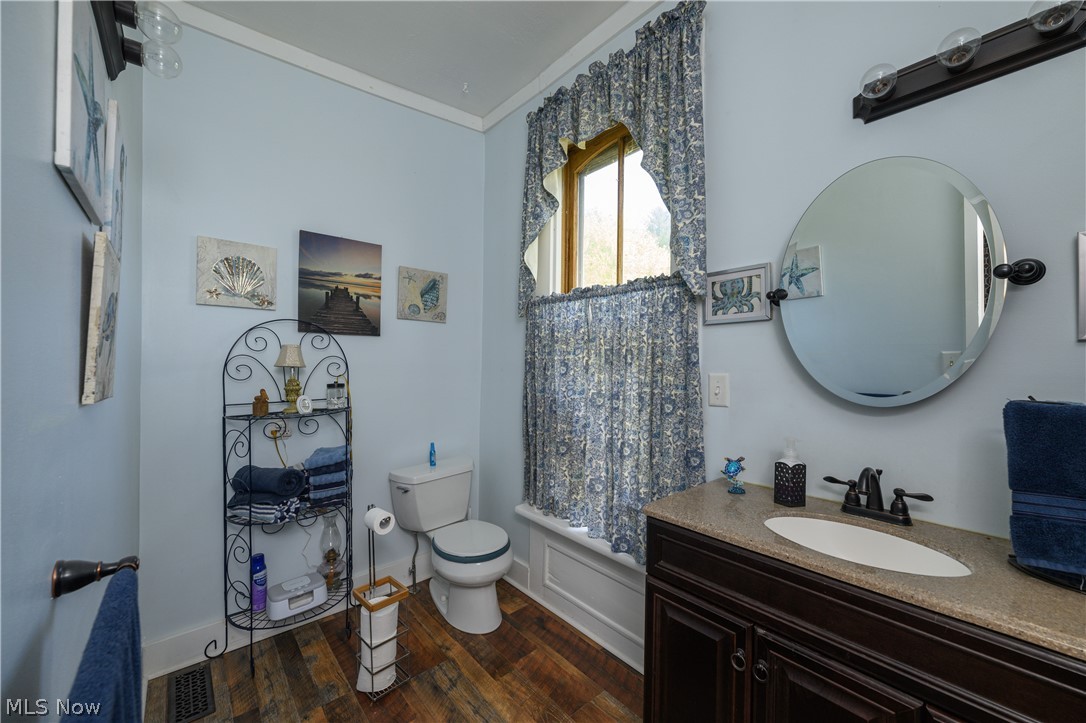 79405 Freeport Tippecanoe Road Tippecanoe, OH 44699 - Photo 33 of 42 Bathroom with vanity, hardwood / wood-style flooring, crown molding, and toilet