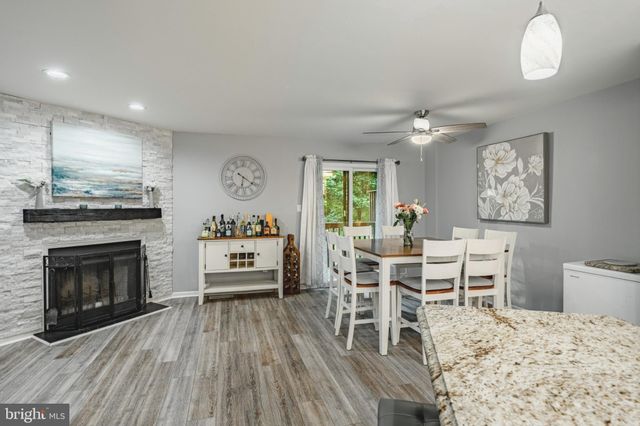a living room with furniture a fireplace and a dining table with wooden floor