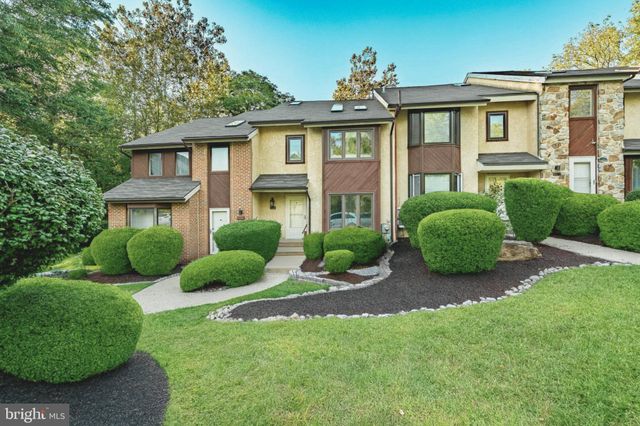 a view of front of a brick house with a yard