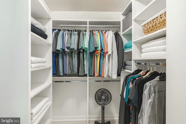 a view of walk in closet with clothes and shoes