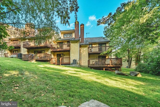 a view of a house with a big yard and large trees