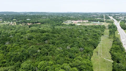 an aerial view of residential houses with outdoor space and trees