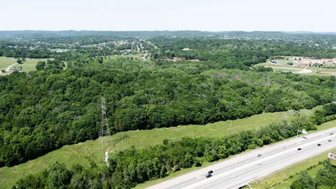 an aerial view of residential houses with outdoor space and trees