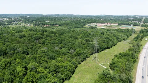 an aerial view of residential houses with outdoor space and trees