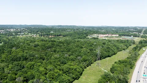 an aerial view of residential houses with outdoor space and trees