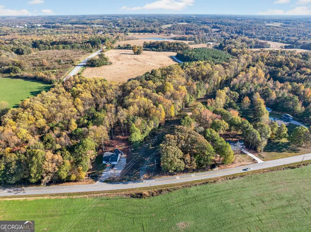 an aerial view of residential houses with outdoor space and trees