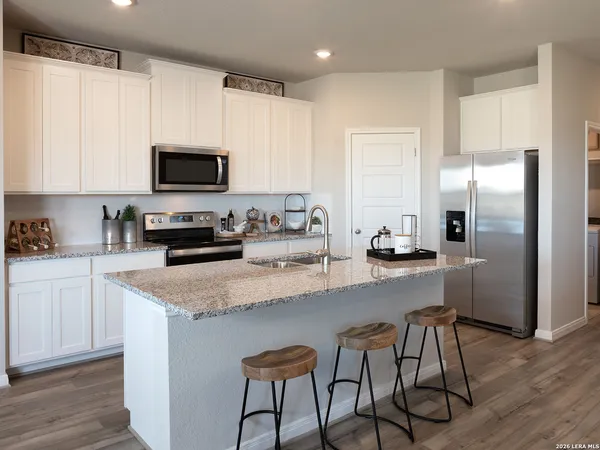 a kitchen with kitchen island a refrigerator stove microwave and cabinets