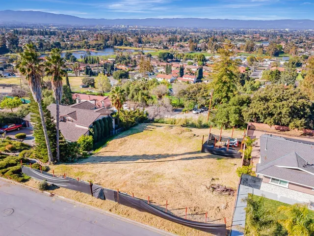 an aerial view of residential houses with outdoor space and trees