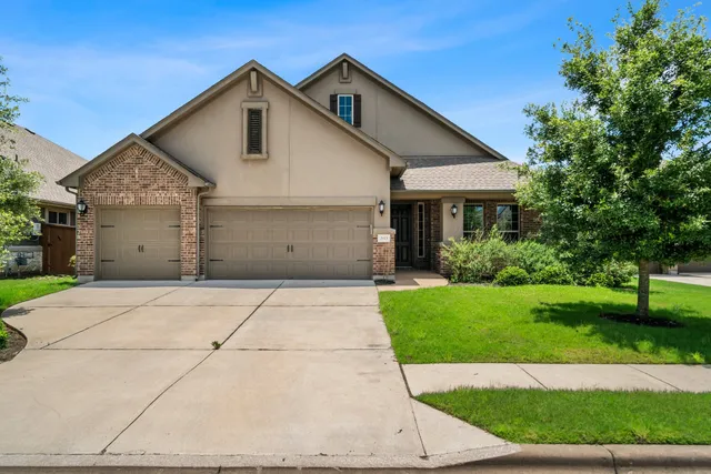 a front view of a house with a yard and garage