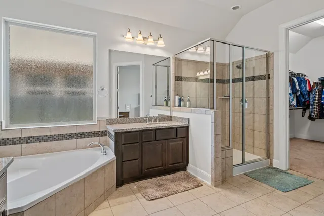 a spacious bathroom with a tub shower and sink