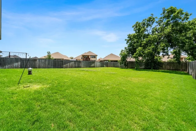 a view of a green field with wooden fence