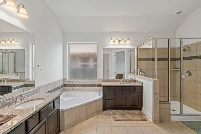 a bathroom with a granite countertop sink mirror and bathtub