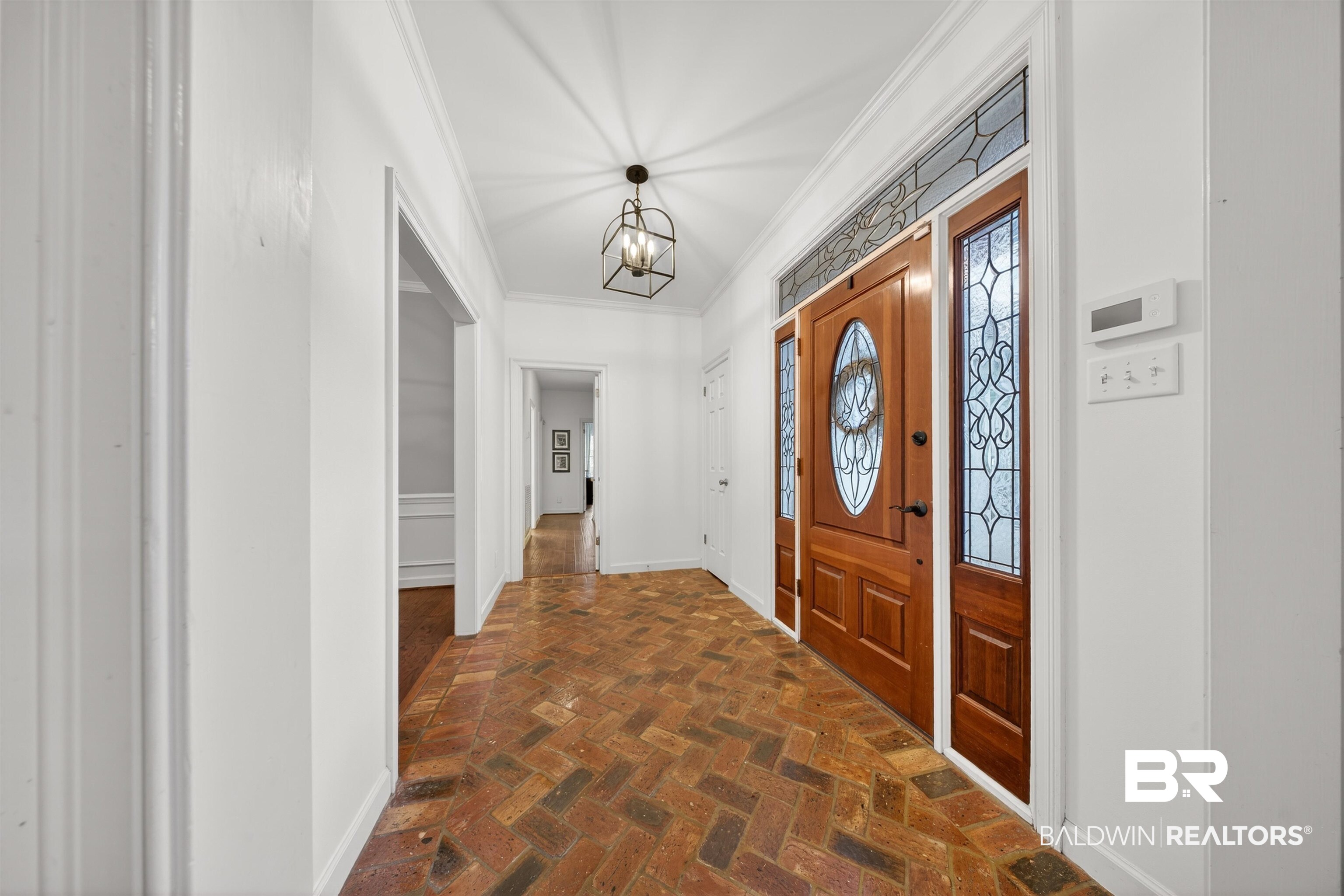1250 Savannah Drive Mobile, AL 36609 - Photo 7 of 35 Foyer entrance featuring ornamental molding, brick flooring, and a chandelier