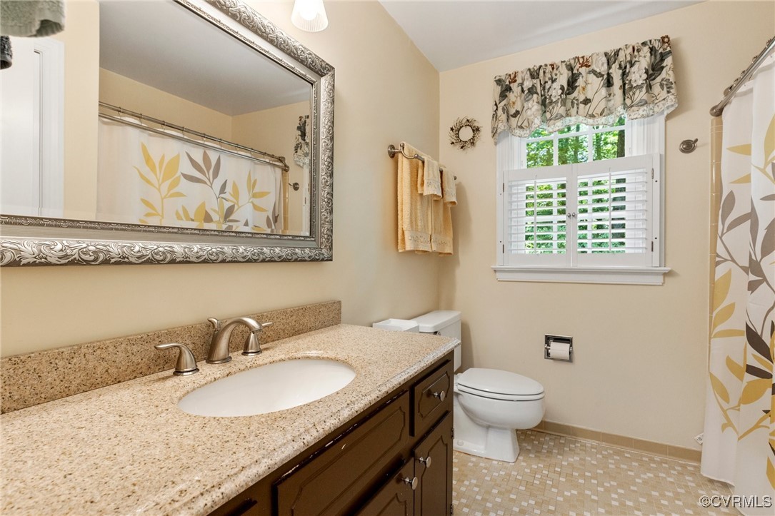 4018 Timber Ridge Road Midlothian, VA 23112 - Photo 32 of 43 a bathroom with a granite countertop toilet a sink and a mirror