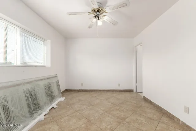 an empty room with windows and fan