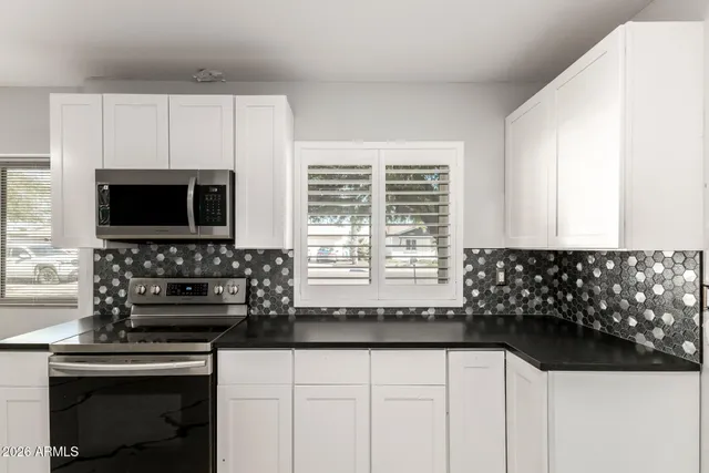 a kitchen with granite countertop a sink and a stove top oven