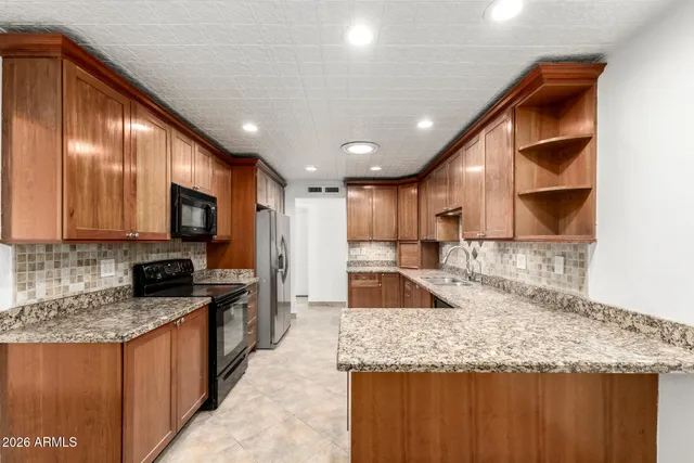 a kitchen with stainless steel appliances granite countertop a sink stove and refrigerator