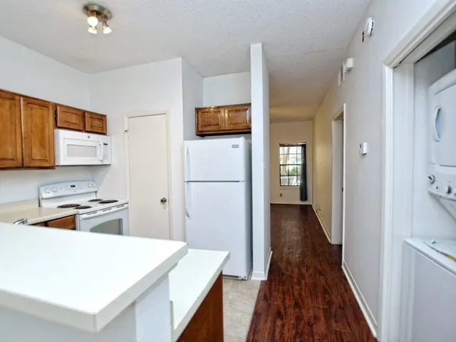 a kitchen with a refrigerator and a stove top oven
