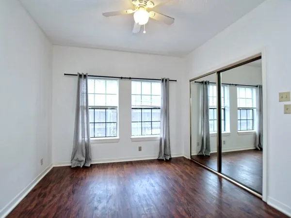 an empty room with wooden floor and windows
