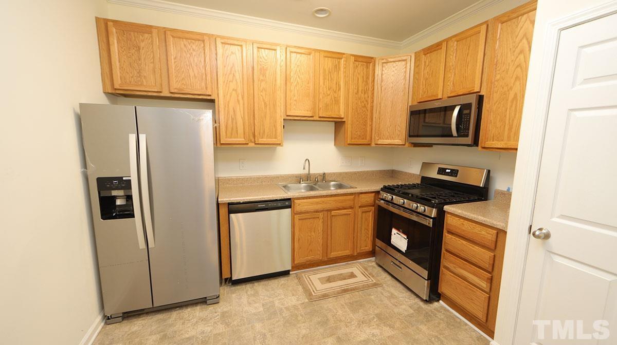11710 Coppergate Drive, Unit 109 Raleigh, NC 27614 - Photo 6 of 15 a kitchen with stainless steel appliances granite countertop a refrigerator stove top oven and sink