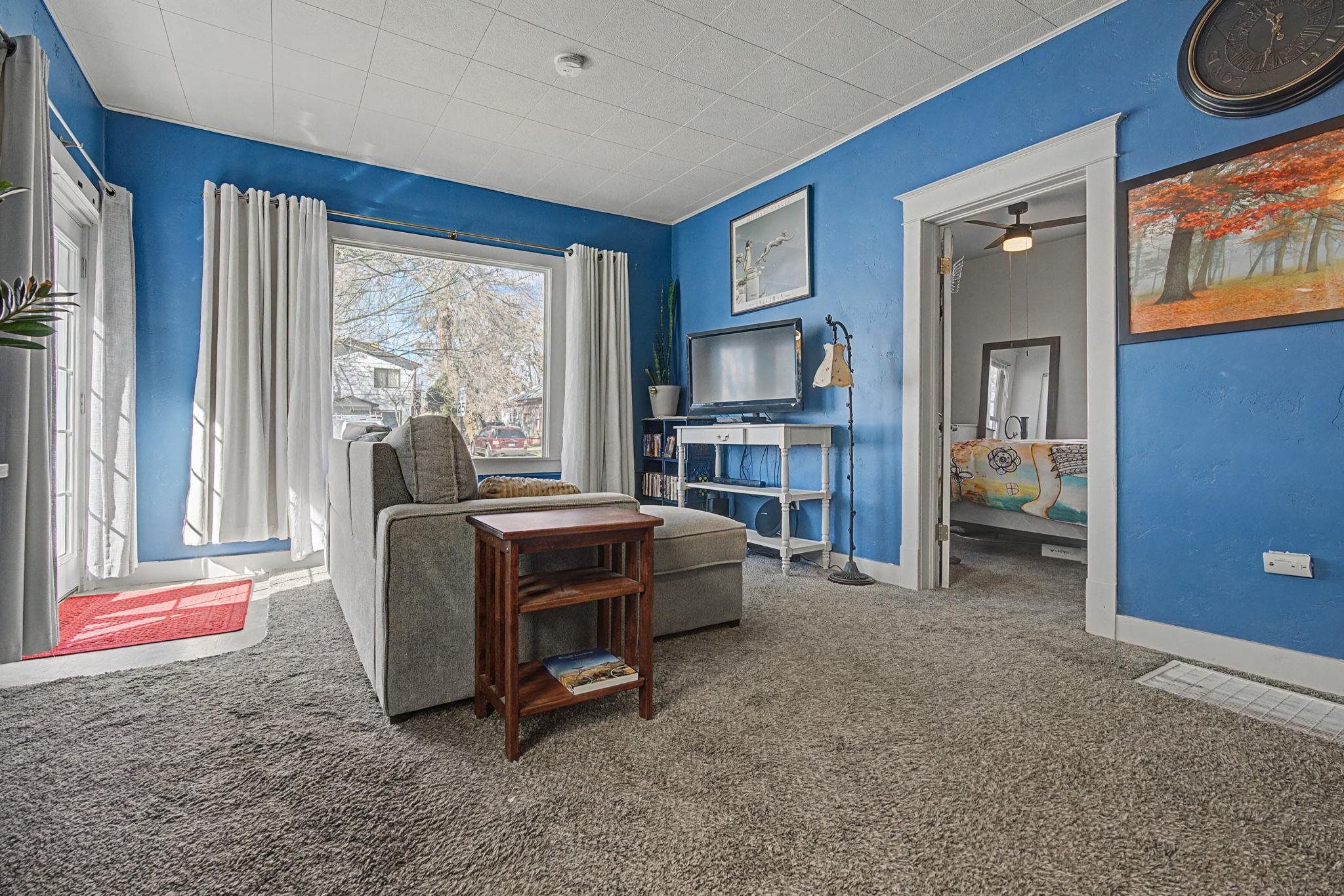 216 4th Street Clifton, CO 81520 - Photo 3 of 17 a living room with a bed furniture a fireplace and a large window