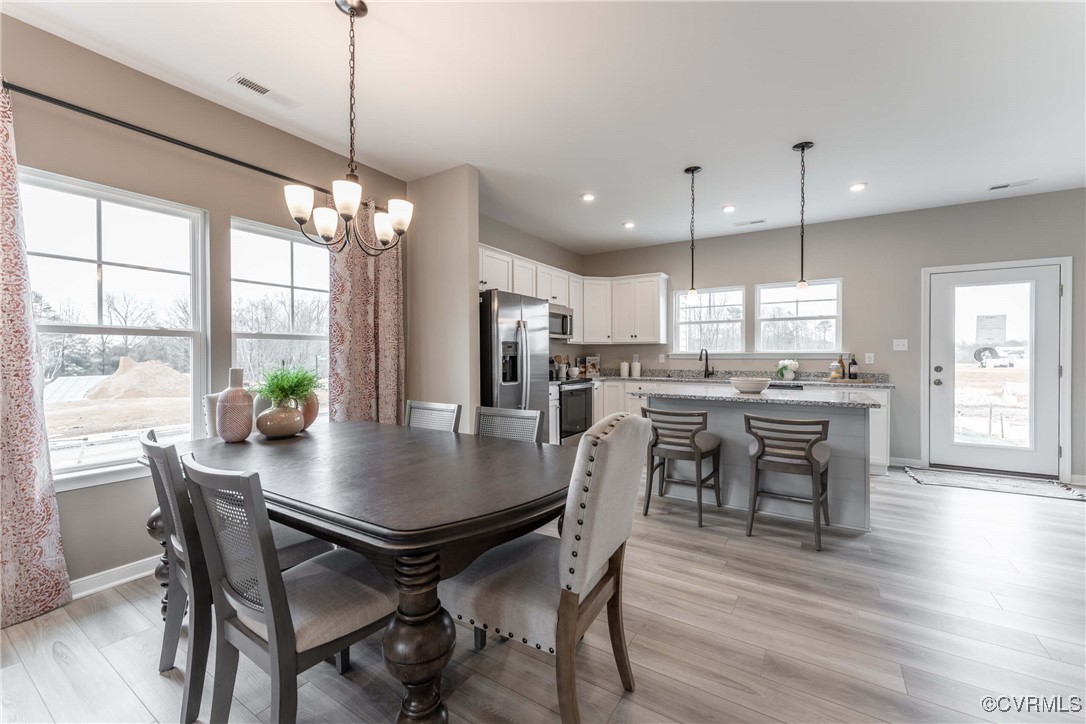233 Greenpark Road Sandston, VA 23150 - Photo 6 of 30 a view of a dining room and livingroom with furniture wooden floor a chandelier