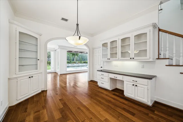 a kitchen with stainless steel appliances granite countertop a stove a sink and white cabinets with wooden floor